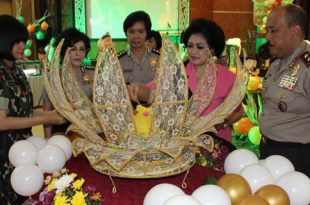 Pemotongan nasi tumpeng oleh Ketua Bhayangkari Polda Sumut Ny Ning Budi Winarso.